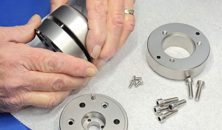 Close-up of a technician performing precision manual assembly of mechanical components